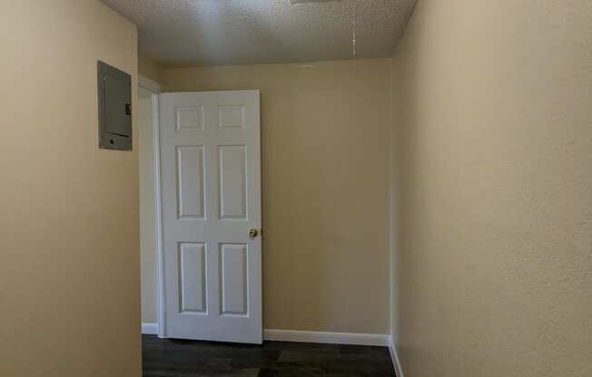 a hallway with a white door and wood flooring