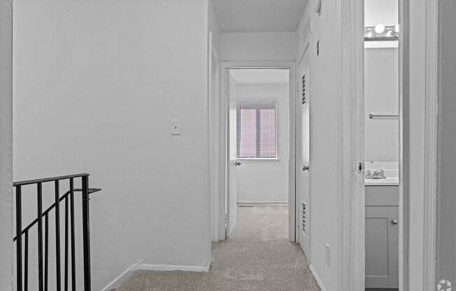 a white room with a staircase and a sink and a window