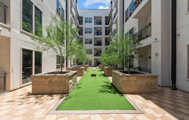 a courtyard with grass and trees in an apartment building