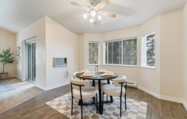 a dining room with a table and chairs and a ceiling fan