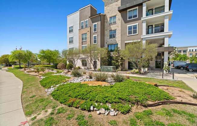 A modern building with a landscaped garden in front.
