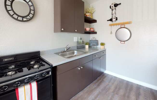 Colton Apartments - Las Brisas Apartment Kitchen with Black Appliances and Wood Cabinets