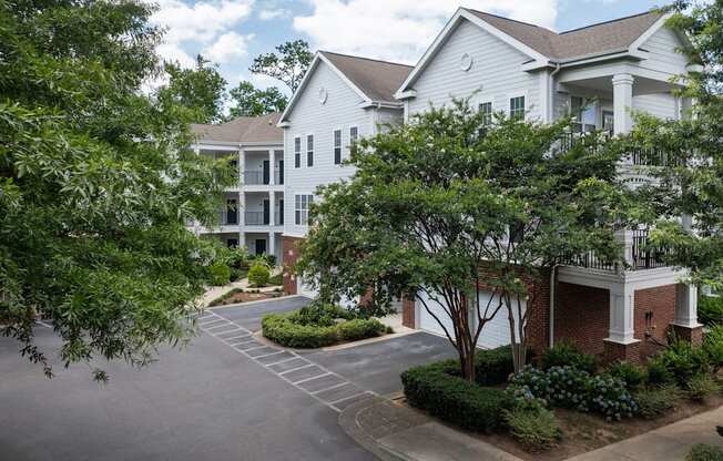 the view of an apartment building with a driveway and trees