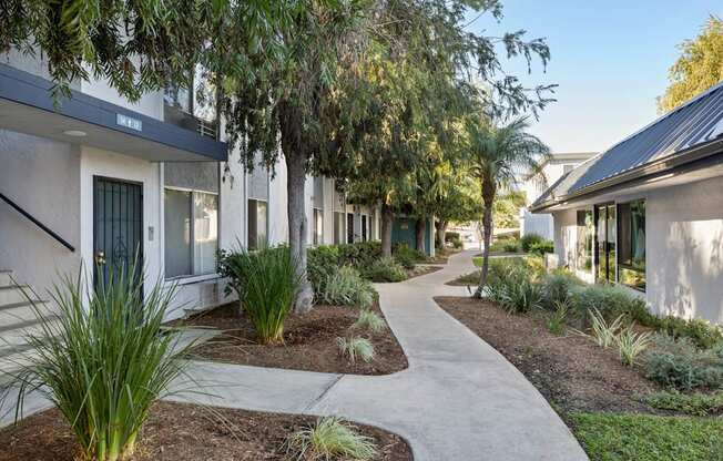 A pathway leads through a landscaped courtyard between two rows of buildings.