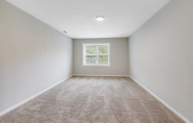 an empty room with carpet and a window