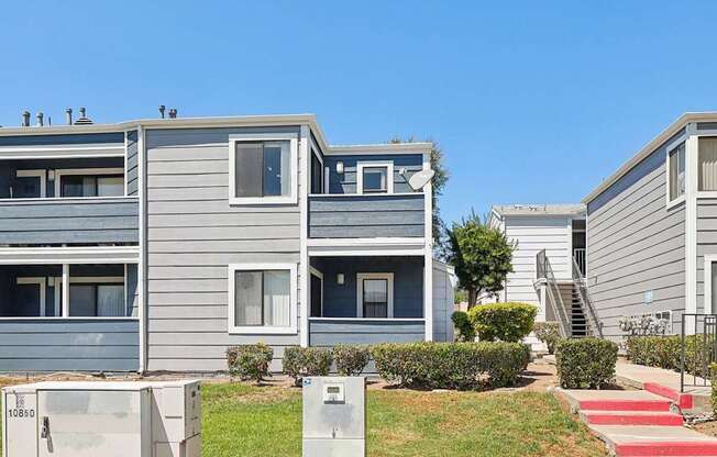 A grey building with a red staircase in front.