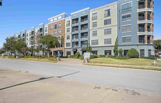 A row of modern apartment buildings are lined up on a street.