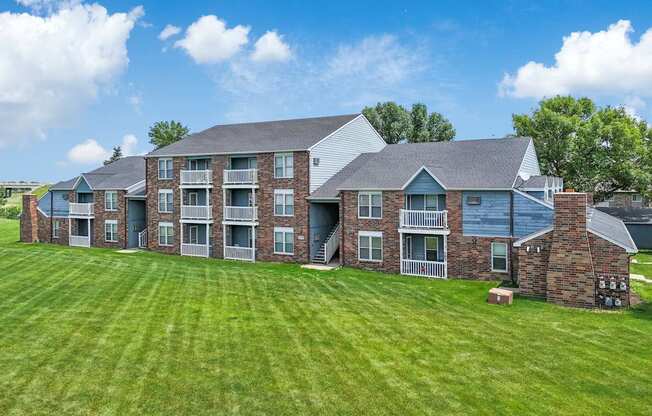 A large building with a green lawn in front.