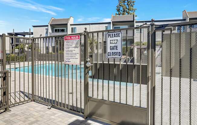 A pool area is gated off with a sign that says Please keep gate closed