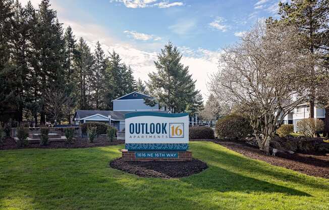 a sign that says outlook 16 with a house and trees in the background