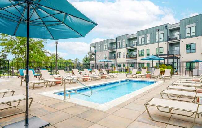 A lounge pool surrounded by several lounge chairs and umbrellas for shade.