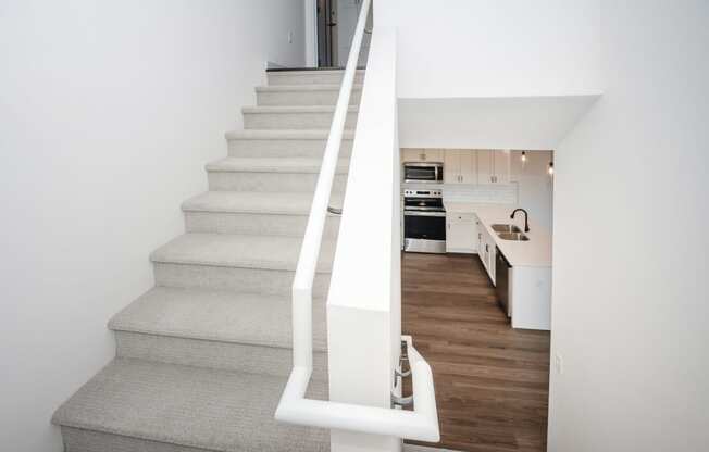 a staircase with white railings leading up to a kitchen in a house at The Crossings at Windsong, Prescott Valley, Arizona