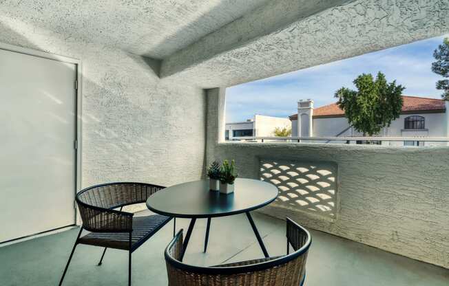 a balcony with a table and chairs and a window