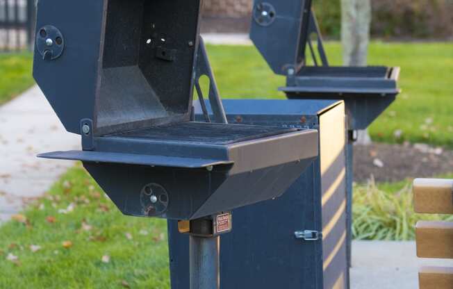 two bbq pits on the side of a sidewalk