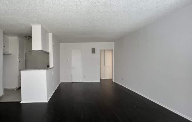 Living room view of open kitchen and hallway to bathroom and bedroom at The Carlton in Hollywood, California.