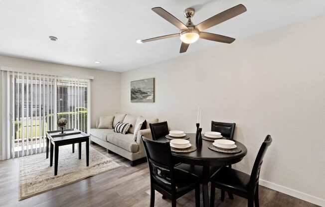 A dining room with a table set for four.