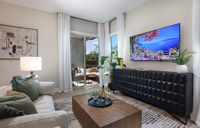 A modern living room with a large flat screen TV mounted on the wall.