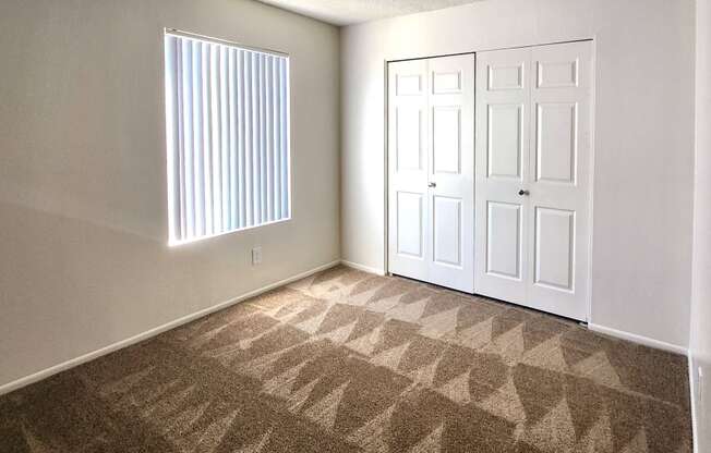 a bedroom with two closets and a window