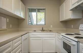 Three Bedroom | Kitchen with white cabinets and white appliances.