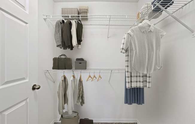 a small walk in closet with white walls and a white closet door with a white door and