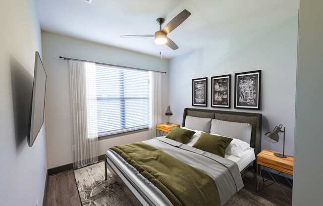 A bedroom with a bed, a ceiling fan, and a television.