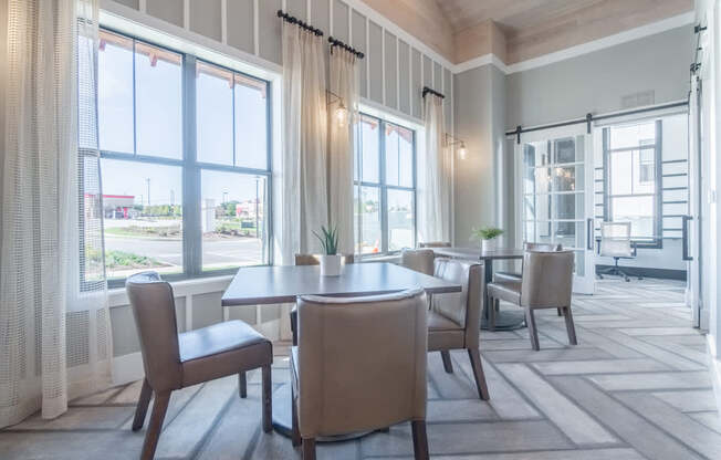 a dining room with a table and chairs and large windows