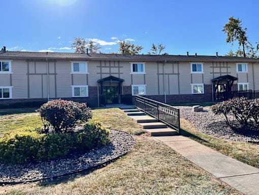 an apartment building with a sidewalk in front of it