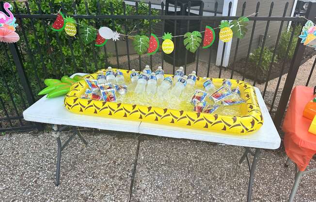 A table with a cake and drinks on it.
