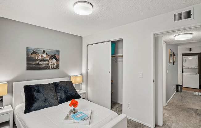 a bedroom with a white bed and a painting on the wall