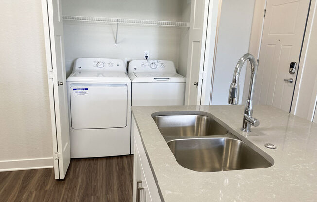 a kitchen with a sink and washer and dryer