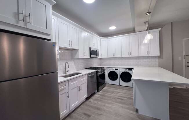 a kitchen with white cabinets and stainless steel appliances