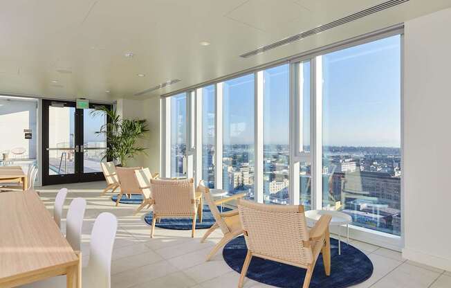 A room with a view of the cityscape through large windows.
