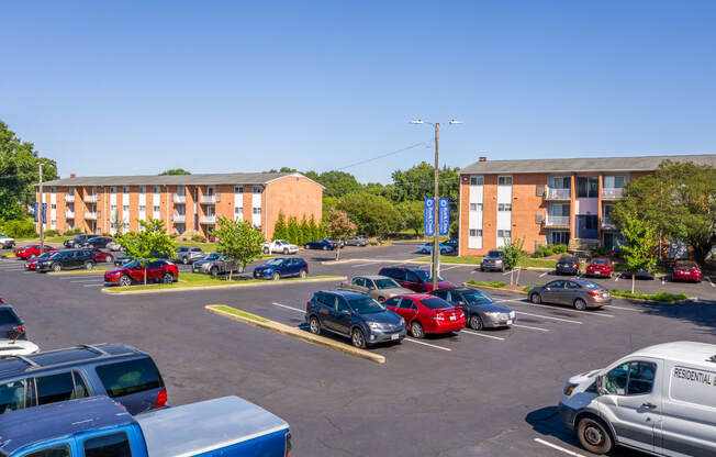 a parking lot with cars in front of an apartment building
