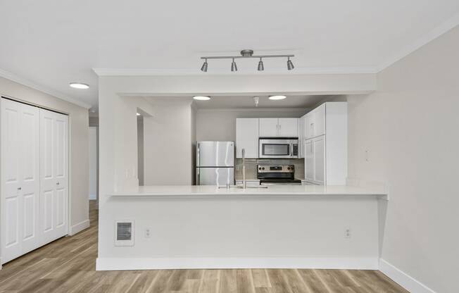 a kitchen with white cabinets and a white counter top