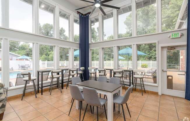 A dining room with a table and chairs and a ceiling fan.
