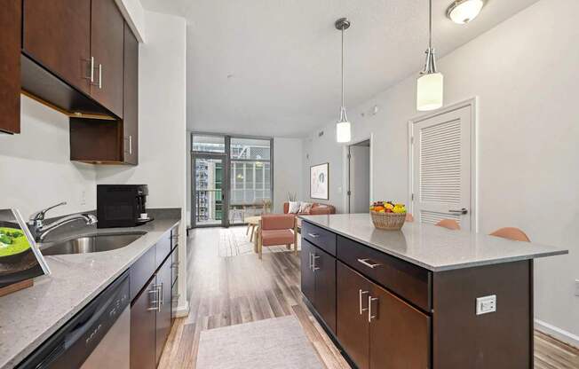 A kitchen with dark wood cabinets and a marble countertop.