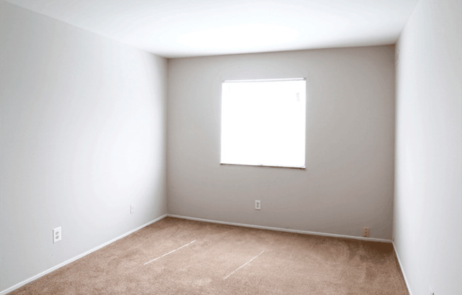 a room with white walls and a window