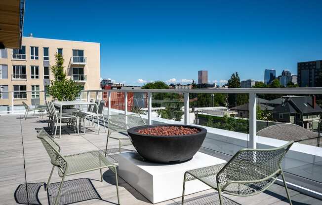 a fire pit on a rooftop terrace with chairs and tables at Slabtown Square Apartments, Oregon, 97209