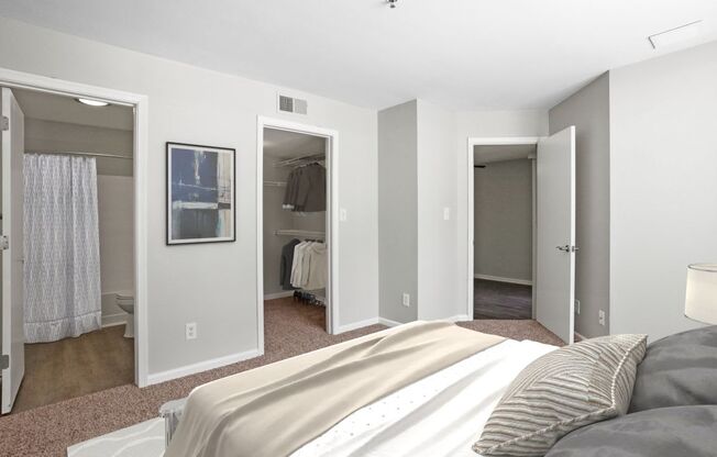 A bedroom with a large bed and a picture on the wall.