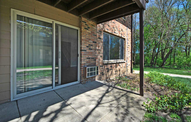 the front porch of a brick house with sliding glass doors