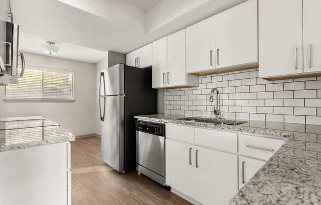 a kitchen with white cabinets and a stainless steel refrigerator at South Lamar Village, Texas, 78704