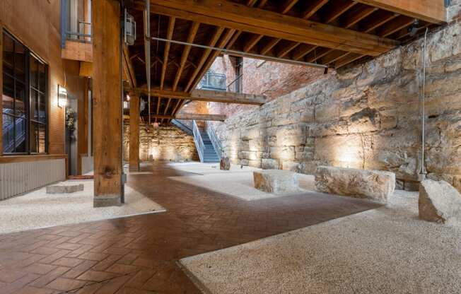 the interior of a building with stone walls and wood beams