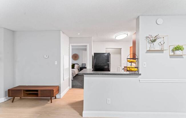 A modern living room with a white wall and a wooden bench.