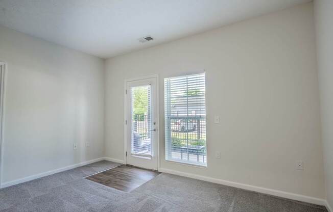 A room with a carpeted floor and a sliding glass door.