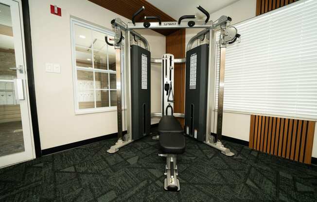 a gym with weights and a chair in the corner of a room