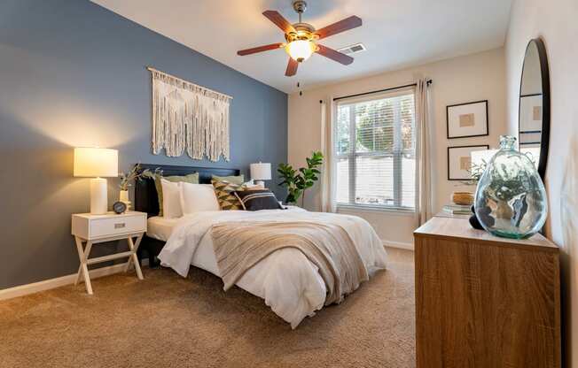 a bedroom with a large bed and a ceiling fan