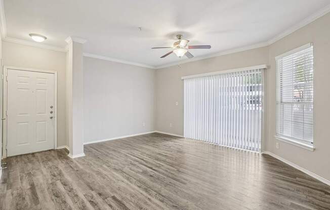 A room with a ceiling fan and a door.