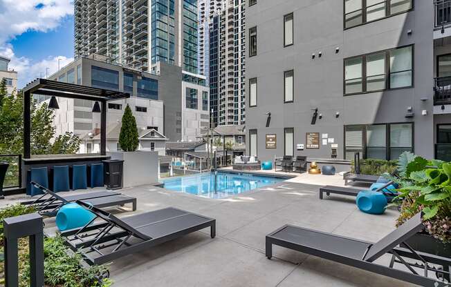 amenities include a pool and lounge chairs at aria on the avenue apartments