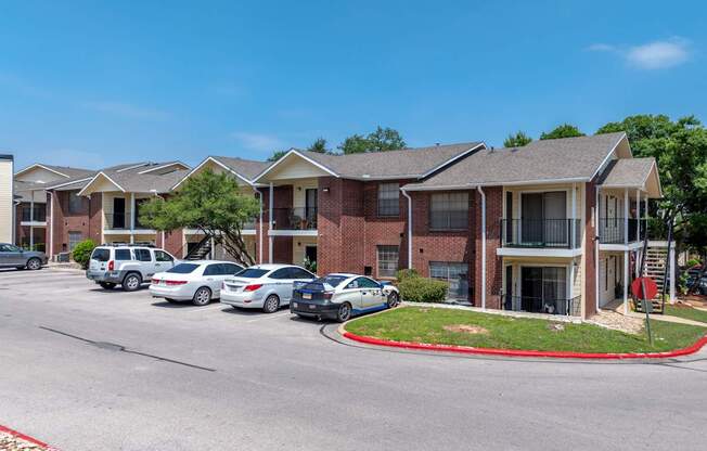 A row of houses with cars parked in front.