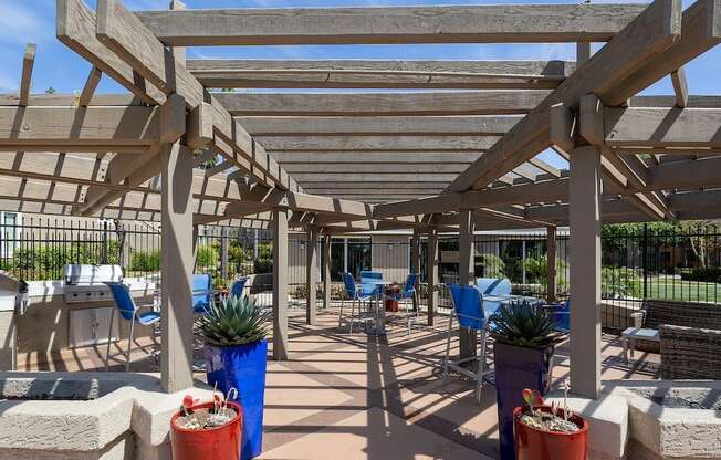 a patio with tables and chairs and a pergola